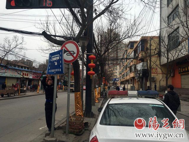 交警灞桥大队秩序中队民警在纺正街维护交通标识牌。严文辉摄